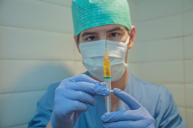 Male nurse holds syringe