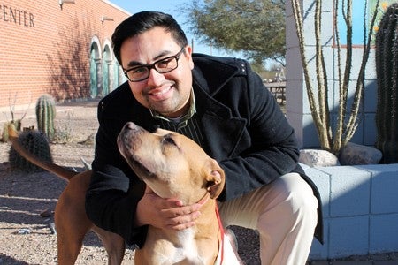 José Ocaño poses outdoors with a dog