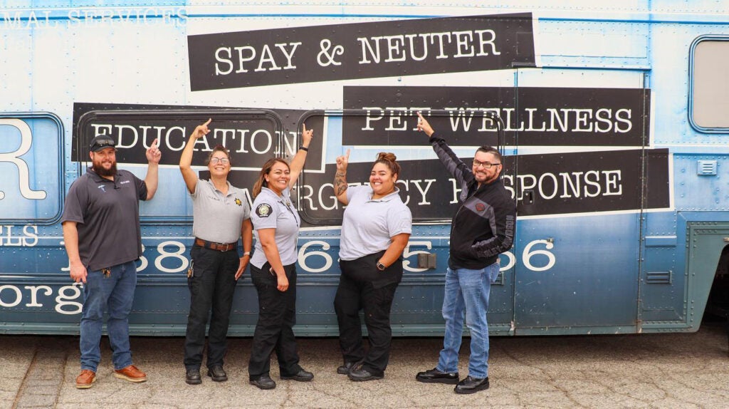 Senior Animal Control Officer Christina Avila (center) and her team celebrate a free spay/neuter clinic in her community.