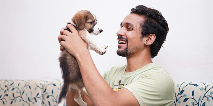 Smiling man holds puppy